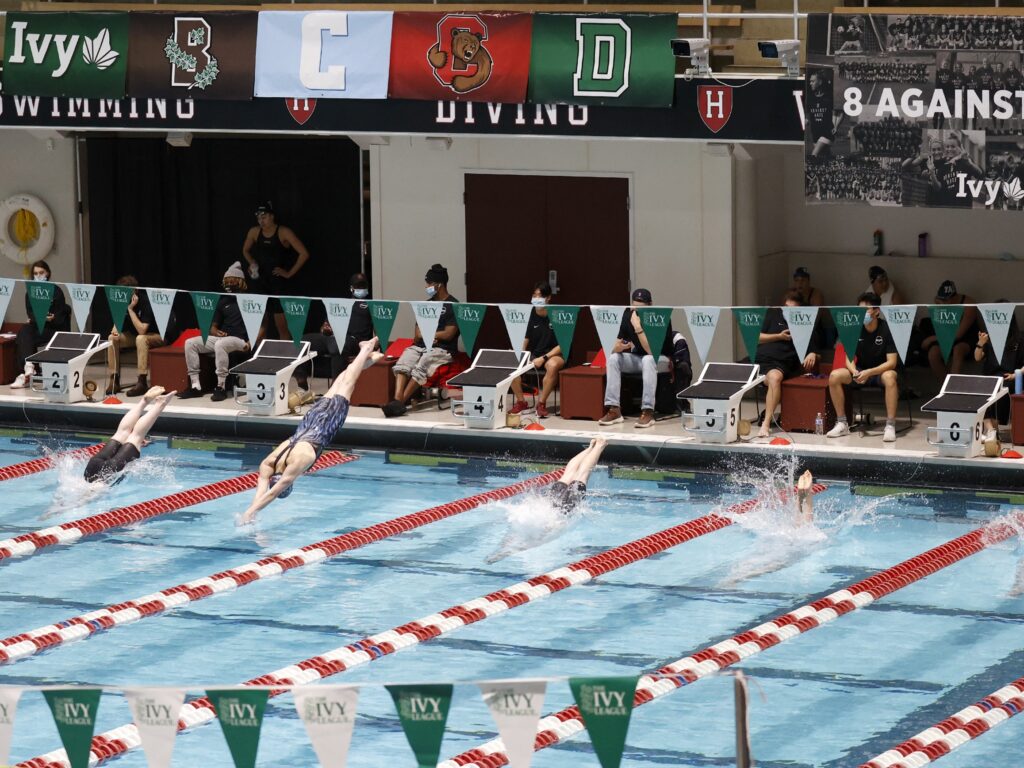 FILE - Swimmers including Penn's Lia Thomas, lane 4, dive into the water at the start of a qualifying heat of the 200 yard freestyle at the Ivy League Women's Swimming and Diving Championships at Harvard University, Feb. 18, 2022, in Cambridge, Mass. (AP Photo/Mary Schwalm, File)