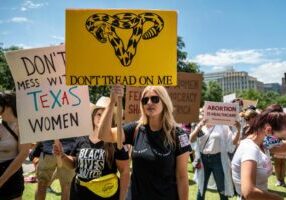 AUSTIN, TX - MAY 29: Protesters hold up signs at a protest outside the Texas state capitol on May 29, 2021 in Austin, Texas. Thousands of protesters came out in response to a new bill outlawing abortions after a fetal heartbeat is detected signed on Wednesday by Texas Governor Greg Abbot. (Photo by Sergio Flores/Getty Images)